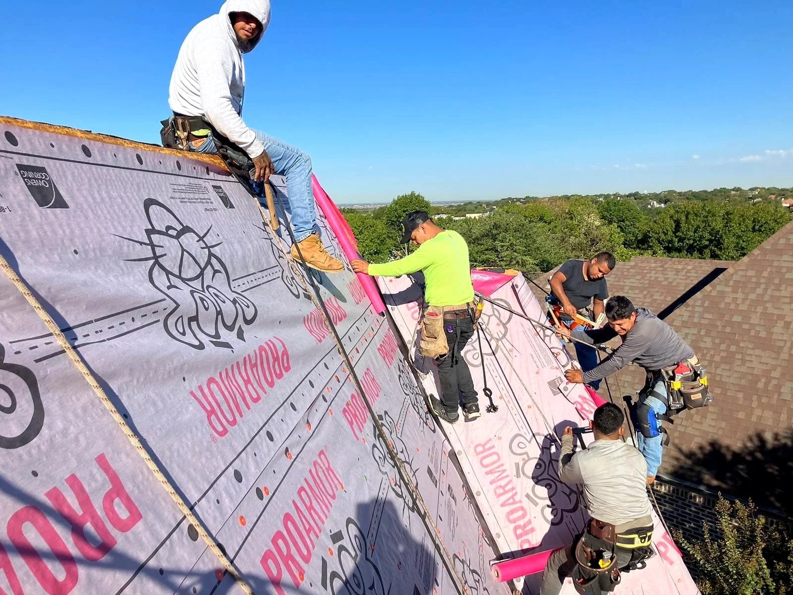 Roofing crew installing underlayment on a Pioneer Roofing project